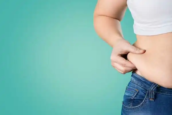 Image of woman pinching her love handles to show weight gain Chesham